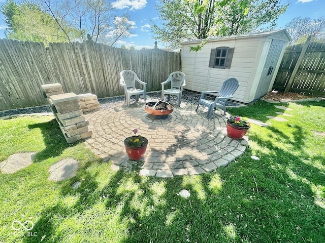view of patio / terrace with a fenced backyard, an outdoor fire pit, an outbuilding, and a storage shed