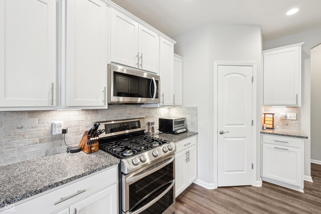9359 Foudray Cir N, Avon, IN 46123 - kitchen featuring stainless steel appliances, wood finished floors, decorative backsplash, light stone counters, and white cabinets
