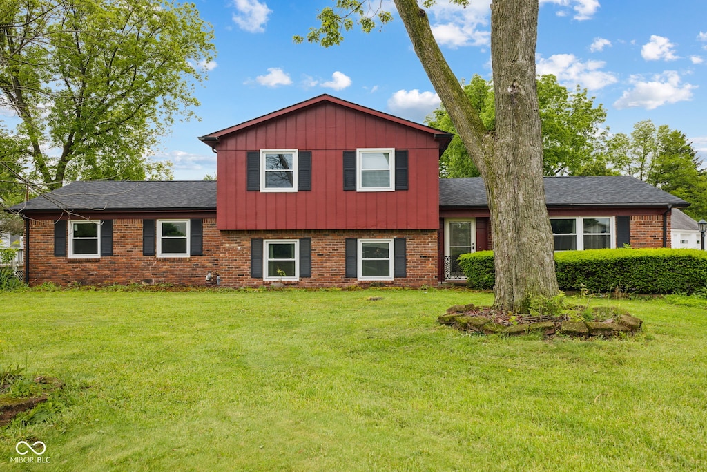 6123 W 46th St, Indianapolis, IN 46254 - split level home featuring brick siding, a front lawn, and board and batten siding