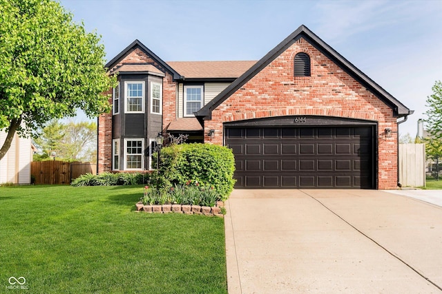 traditional-style home featuring fence, a front yard, brick siding, an attached garage, and driveway