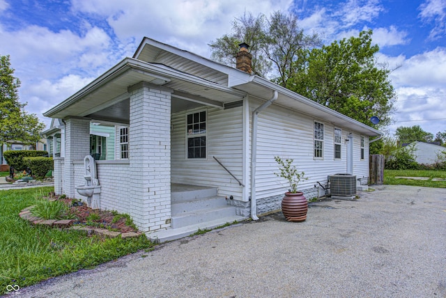 view of front of house with a chimney and central AC