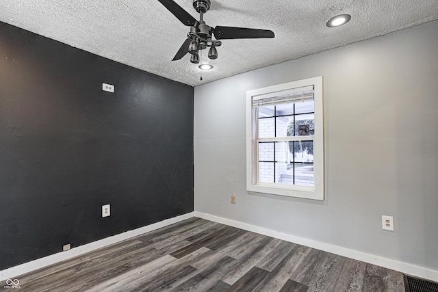 unfurnished room with dark wood-type flooring, a ceiling fan, a textured ceiling, and visible vents