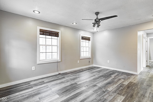 unfurnished room with a ceiling fan, a textured ceiling, wood finished floors, baseboards, and recessed lighting