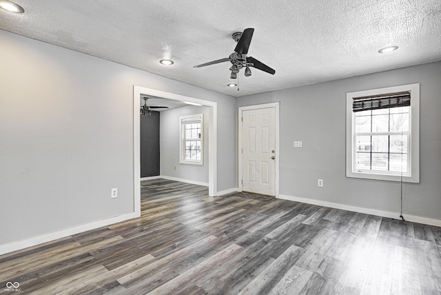 empty room with ceiling fan, a textured ceiling, dark wood finished floors, recessed lighting, and baseboards