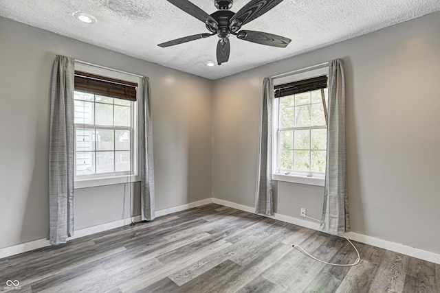 unfurnished room with a ceiling fan, a textured ceiling, plenty of natural light, and wood finished floors