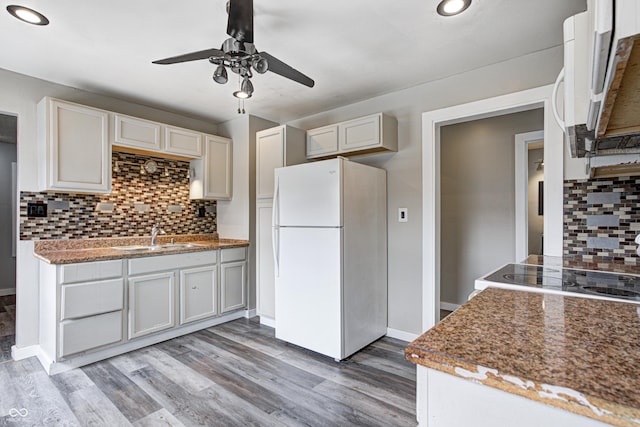 kitchen featuring a ceiling fan, white appliances, light wood-type flooring, tasteful backsplash, and a sink