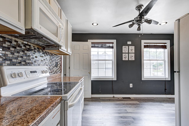 kitchen featuring backsplash, a ceiling fan, wood finished floors, baseboards, and white appliances