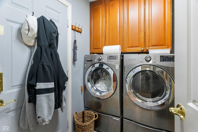 clothes washing area featuring cabinet space and washing machine and clothes dryer
