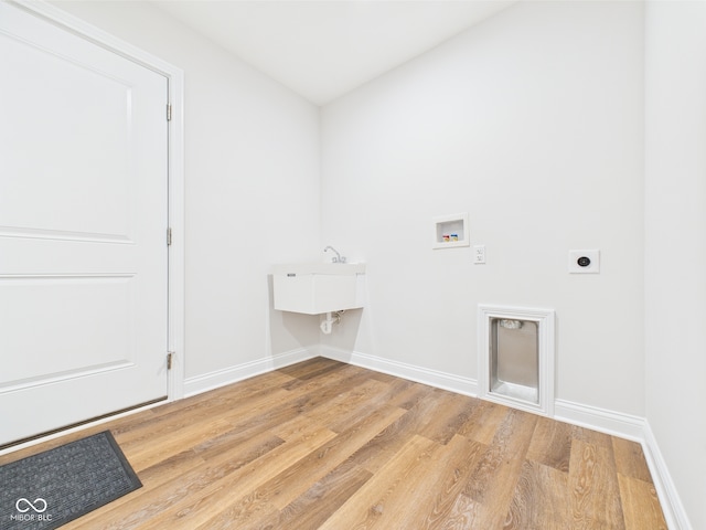 laundry area with baseboards, laundry area, and wood finished floors