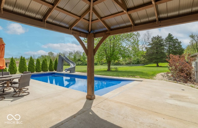 pool with a lawn, a water slide, a gazebo, and a patio area