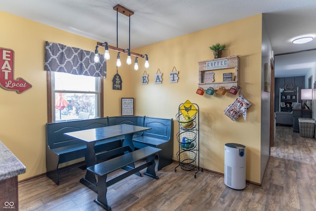 dining area with baseboards and wood finished floors