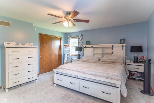 bedroom featuring visible vents, a ceiling fan, and light colored carpet