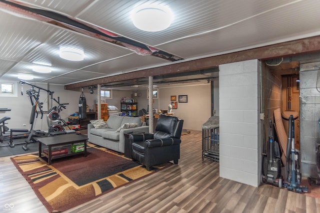 living room with concrete block wall and wood finished floors