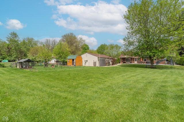 view of yard featuring fence and an outbuilding