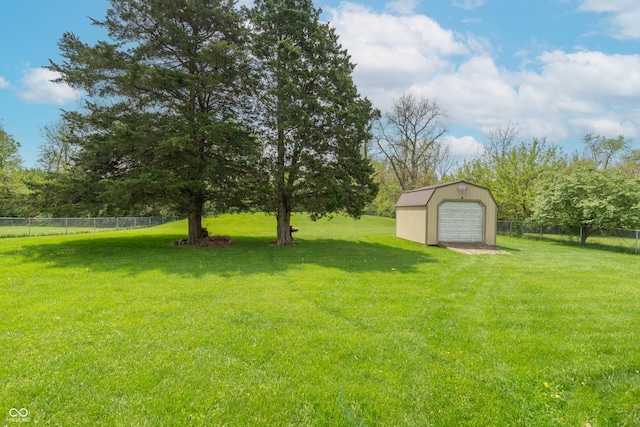 view of yard featuring fence, an outdoor structure, and a garage