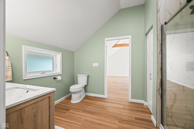 bathroom featuring a marble finish shower, toilet, wood finished floors, and lofted ceiling
