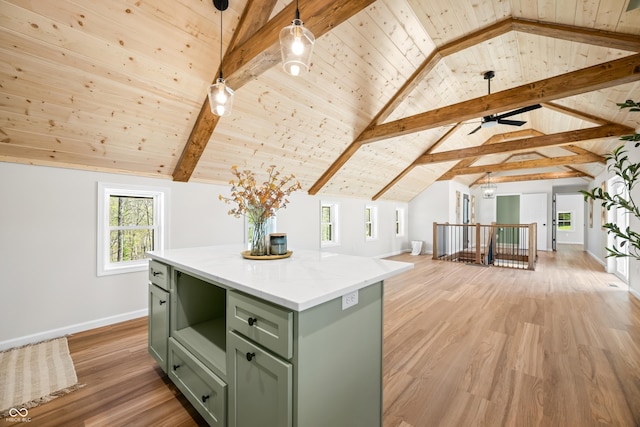 kitchen featuring a kitchen island, baseboards, light wood-style floors, vaulted ceiling with beams, and green cabinets