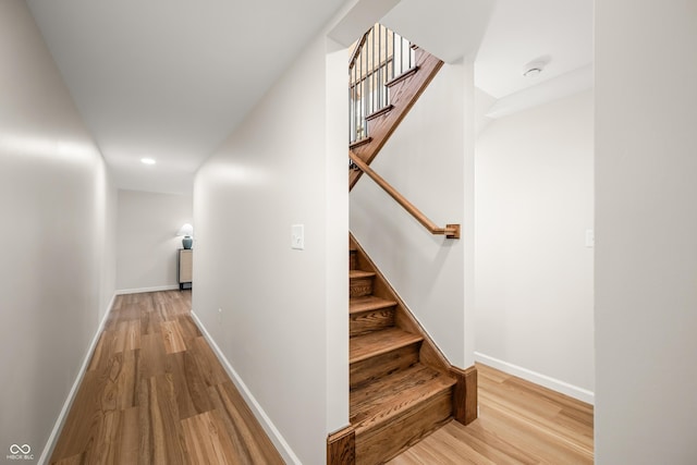 stairway featuring recessed lighting, baseboards, and wood finished floors