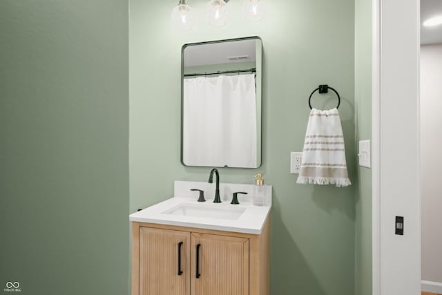 full bath with vanity, baseboards, and visible vents