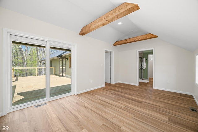 unfurnished living room with baseboards, visible vents, light wood-style flooring, and vaulted ceiling