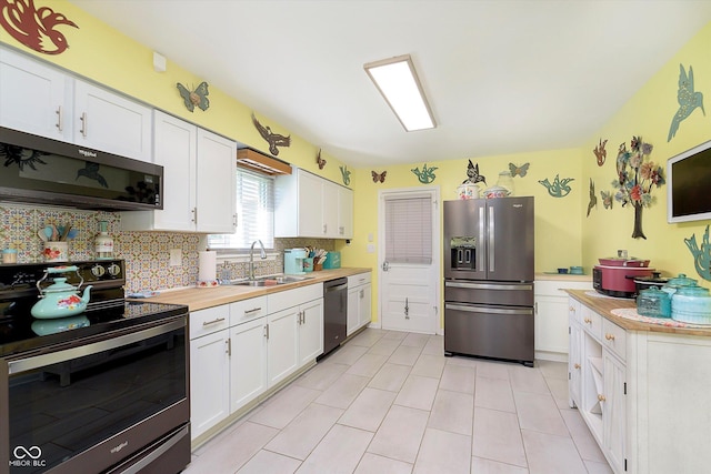 kitchen featuring backsplash, a sink, light tile patterned floors, white cabinets, and stainless steel appliances