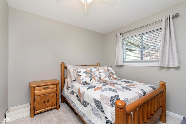 bedroom featuring light colored carpet, a ceiling fan, and baseboards