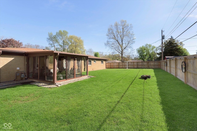 view of yard with a sunroom and a fenced backyard