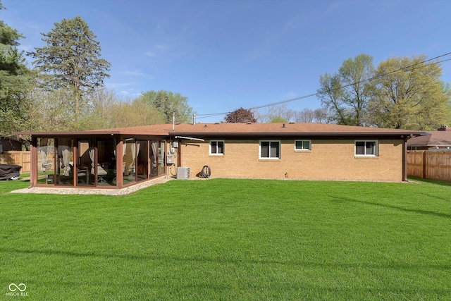 back of house featuring a lawn, central AC, and fence