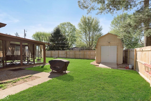 view of yard with a fenced backyard, an outbuilding, and a shed