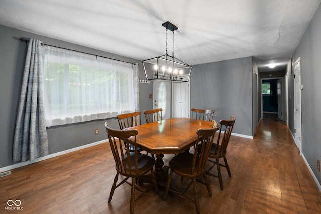 dining area with an inviting chandelier, baseboards, and wood finished floors