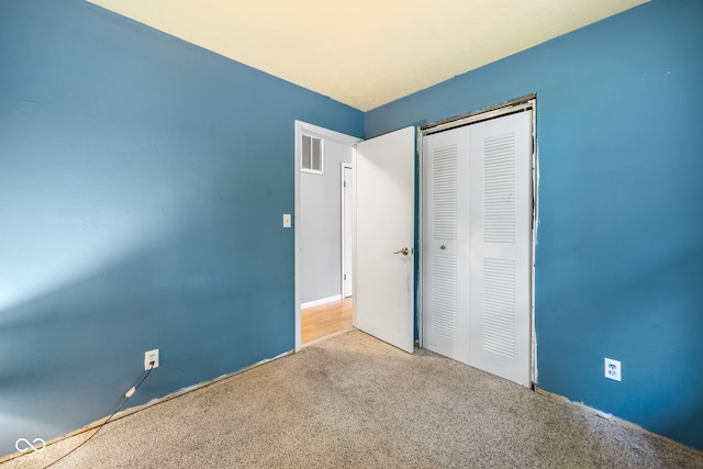 unfurnished bedroom featuring a closet, visible vents, and carpet floors