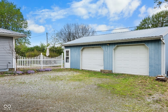 detached garage featuring fence