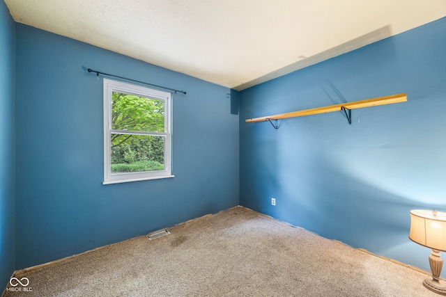 empty room with visible vents and carpet floors