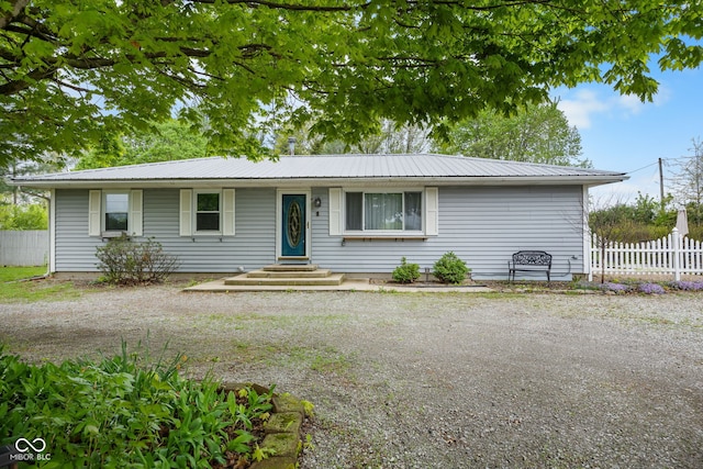 single story home with fence and metal roof