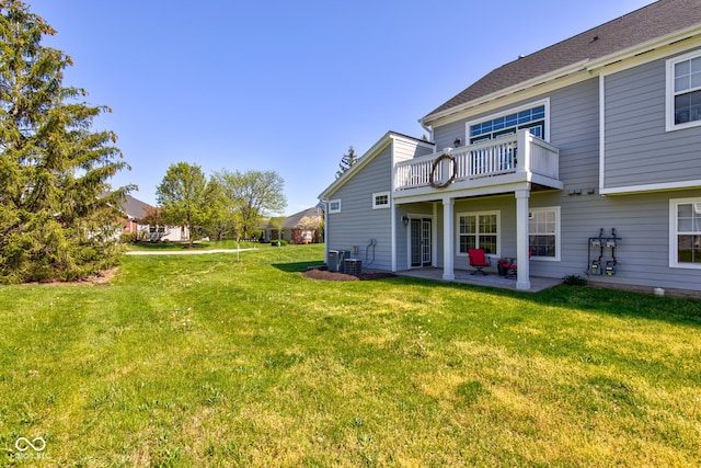 back of property with a lawn, a patio, and a balcony