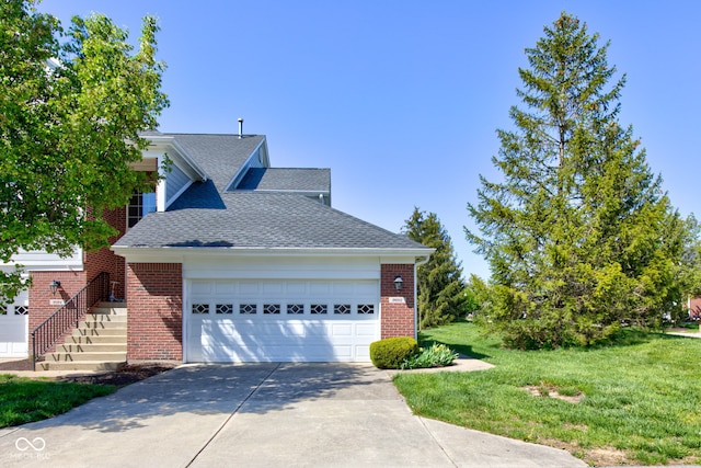 view of front facade featuring a shingled roof, a front lawn, brick siding, a garage, and driveway
