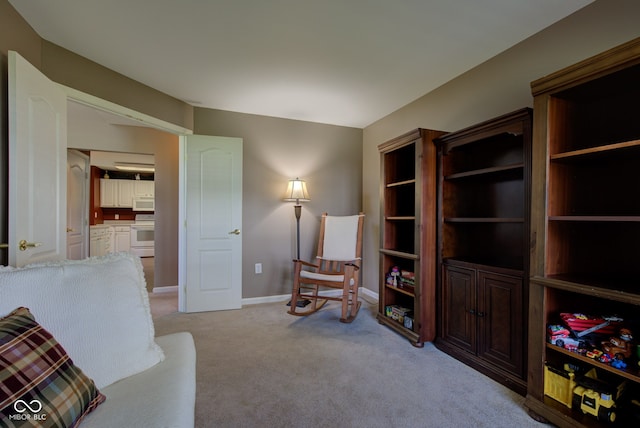 living area with light colored carpet and baseboards
