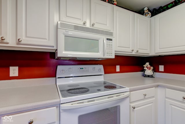 kitchen with light countertops, white cabinetry, and white appliances