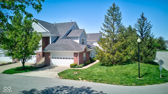 view of front facade with a front yard, brick siding, a shingled roof, an attached garage, and driveway