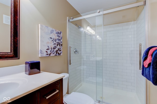 full bathroom with vanity, a shower stall, toilet, and visible vents