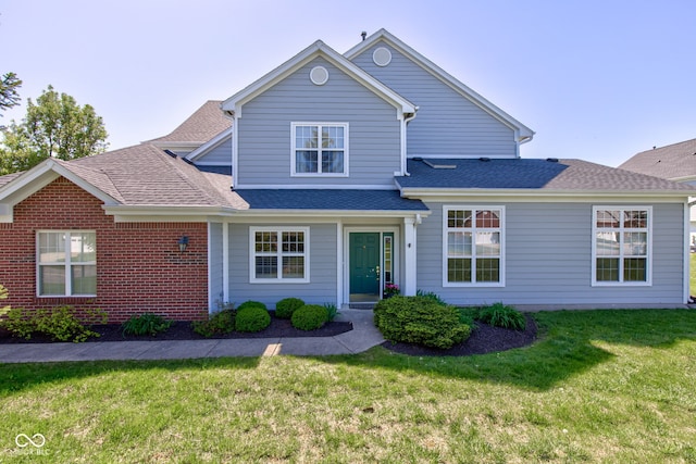 traditional home featuring roof with shingles and a front lawn