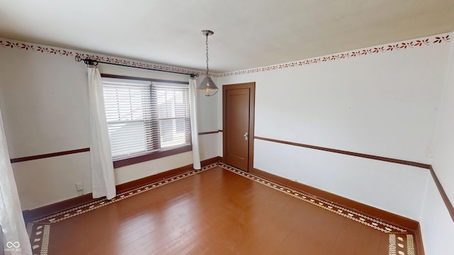 empty room featuring baseboards and dark wood-style floors
