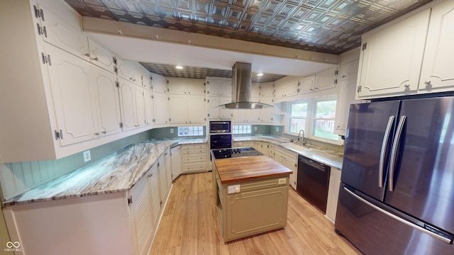 kitchen with an ornate ceiling, wood counters, appliances with stainless steel finishes, and island range hood