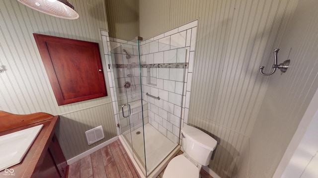 full bathroom with vanity, toilet, wallpapered walls, wood finished floors, and a stall shower