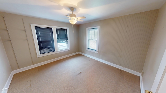 unfurnished room with carpet flooring, a ceiling fan, and baseboards