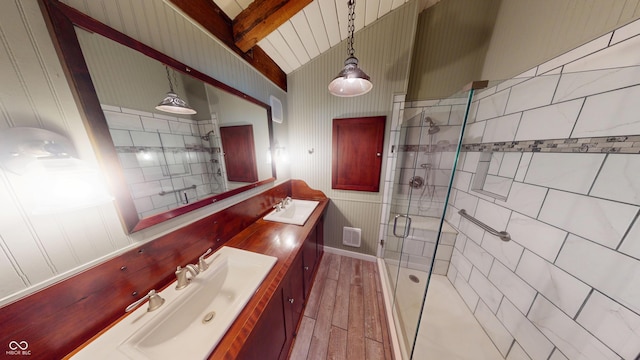 bathroom featuring double vanity, a sink, wood finished floors, and a stall shower