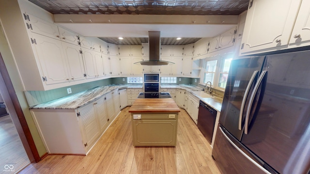 kitchen with butcher block counters, light wood-type flooring, island exhaust hood, a sink, and stainless steel appliances