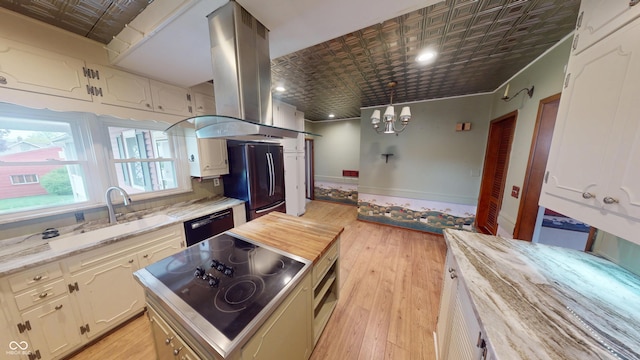 kitchen featuring island exhaust hood, an ornate ceiling, black appliances, light wood finished floors, and a notable chandelier