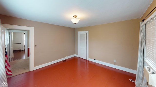 empty room featuring visible vents, baseboards, and wood finished floors