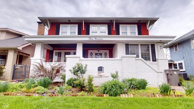 american foursquare style home featuring a porch and brick siding